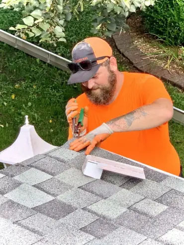 Installer fitting MasterShield gutter guards to a roofline